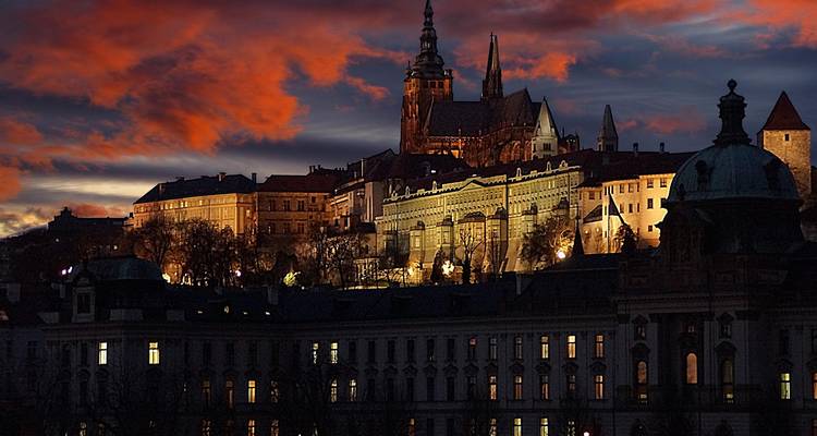 El Castillo de Praga y la Catedral de San Vito recortados contra las nubes del atardecer dramático sobre la ciudad.