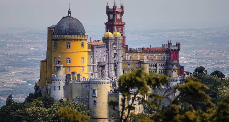Der lebendige gelb und rot gefärbte Pena-Palast thront auf einem bewaldeten Hügel über dem Sintra-Tal.