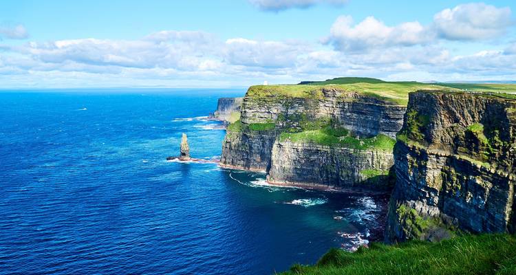 Los imponentes Acantilados de Moher que se desploman en el profundo Atlántico azul con pilas de mar y cabos cubiertos de hierba.