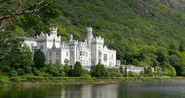 La Abadía de Kylemore reflejada en un lago tranquilo al pie de las verdes colinas de Connemara.