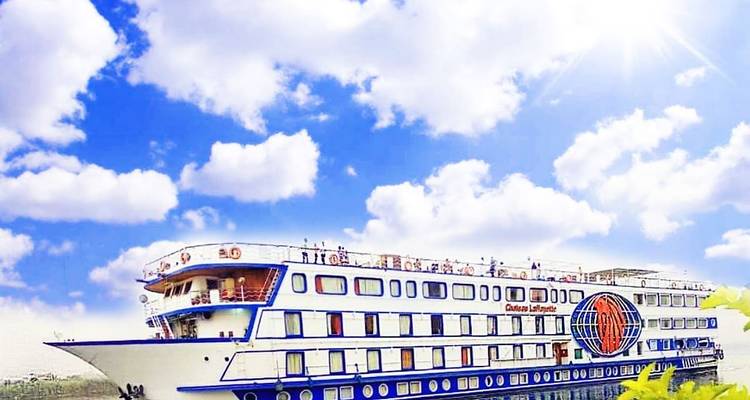 Bateau de croisière blanc et bleu naviguant sur le Nil sous un ciel ensoleillé parsemé de nuages épars