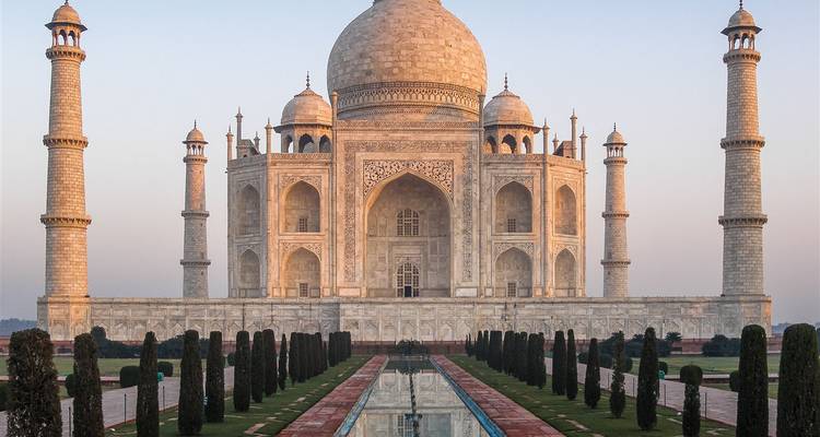 Close symmetrische opname van het Taj Mahal tijdens het gouden uur, waarbij ingewikkelde marmeren details naar voren komen.