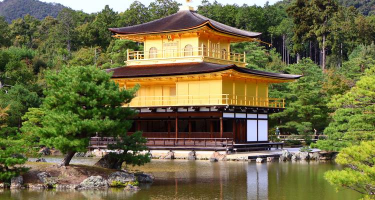 Golden Pavilion Kinkaku-ji reflected in its pond with surrounding pine trees