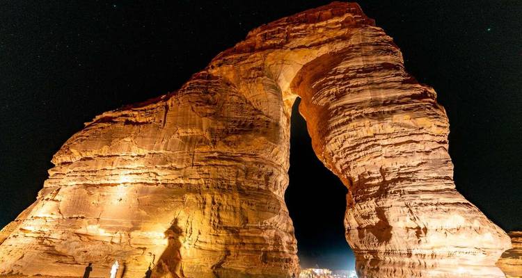 Nachtaanzicht van de verlichte rotsformatie, bekend als Elephant Rock, in de woestijn van Al-Ula.
