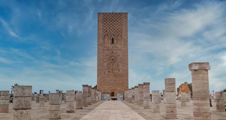 La Torre de Hassan domina una plaza de columnas de piedra bajo un cielo parcialmente nublado en Rabat.