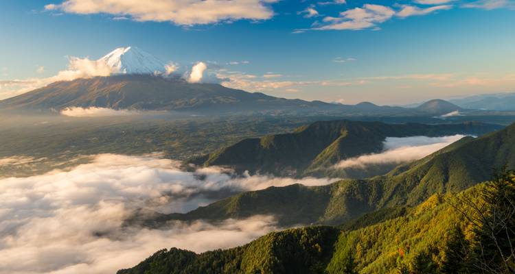 El Monte Fuji se eleva sobre ondulantes crestas verdes y una manta de nubes matutinas en un panorama de altura que te deja sin aliento.