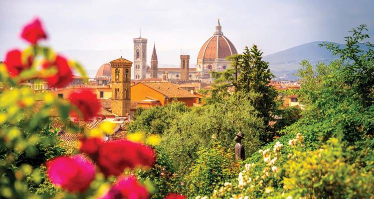 Skyline emblématique de Florence aux toits rouges avec le Dôme encadré par des roses en fleur au premier plan.