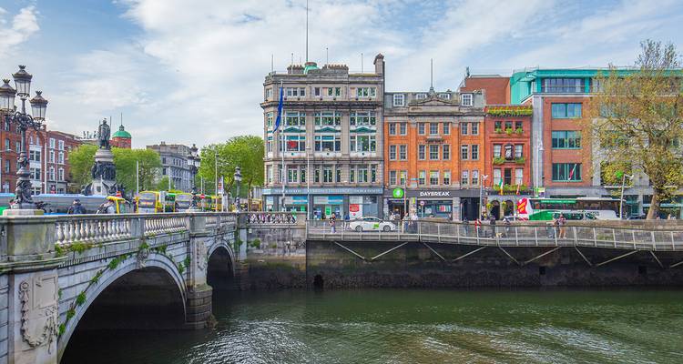 Des bâtiments colorés au bord de la rivière et un pont en pierre enjambent la rivière Liffey dans une scène animée du centre-ville.