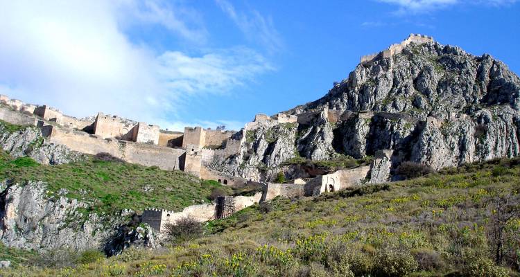 Steinbefestigungen, die einen steilen Felshang unter einem strahlend blauen Himmel hinaufführen