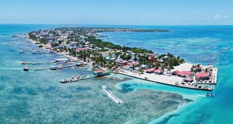 Vue aérienne d'une île tropicale étroite avec des récifs turquoise et des bateaux