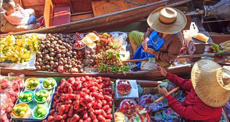 Scène colorée du marché flottant avec des vendeurs dans des bateaux chargés de fruits et légumes tropicaux.