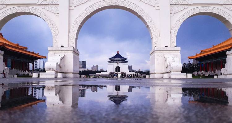 Symmetrische Spiegelung des Chiang-Kai-shek-Denkmals durch die Bögen des Liberty Square nach einem Regen.