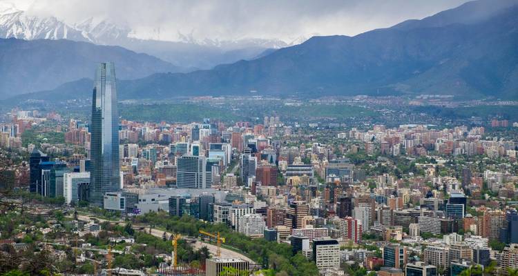 Les gratte-ciel modernes et les îlots urbains densément construits de Santiago s'étendent sur une plaine avec la Cordillère des Andes aux sommets enneigés qui se dresse majestueusement en arrière-plan.