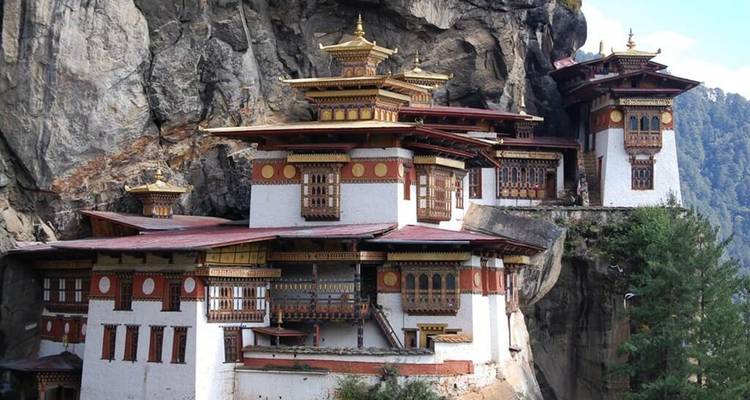 Le célèbre Monastère du Nid du Tigre s'accroche à une paroi rocheuse à pic entourée de montagnes boisées.