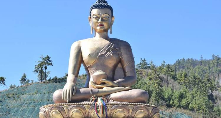 La gigantesque statue du Bouddha assis Dordenma scintillant sous un ciel bleu vibrant.
