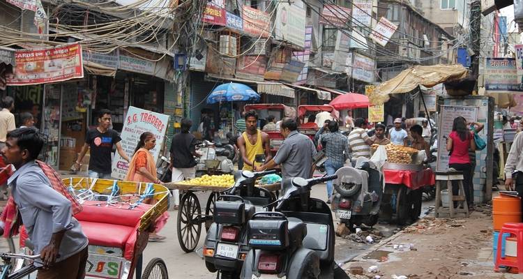 Una calle de mercado concurrida con varias tiendas y gente.