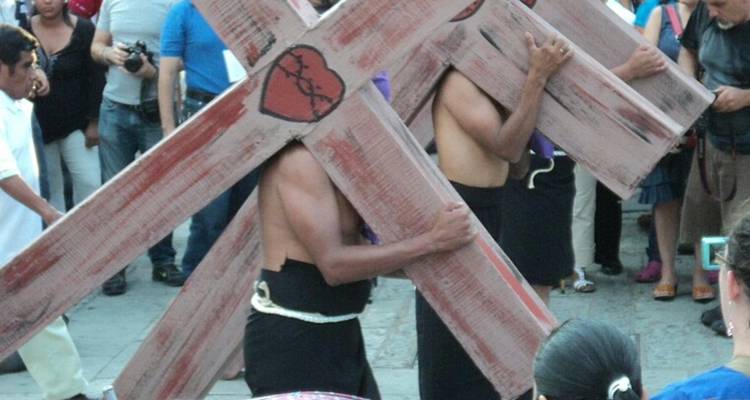 Los penitentes cargan grandes cruces de madera durante una procesión religiosa en Taxco.