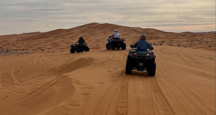 Los conductores en motos de cuatro ruedas trazando caminos a través de las enormes dunas de arena del Sahara en Merzouga.