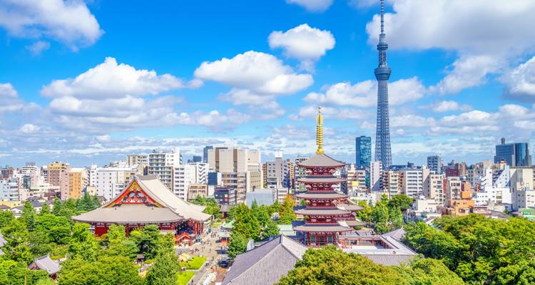Complejo del templo Senso-ji y pagoda de cinco pisos enmarcados por una exuberante vegetación con la Torre Skytree de Tokio elevándose detrás.