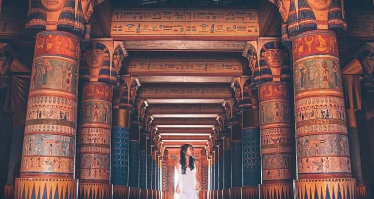 Le visiteur traverse un couloir aux colonnes ornées peint de motifs égyptiens anciens aux Atlas Studios.