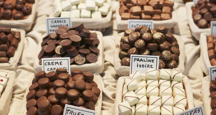 Assortiment de pralines au chocolat faites à la main présentées dans des plateaux en tissu rustique à un étal de marché