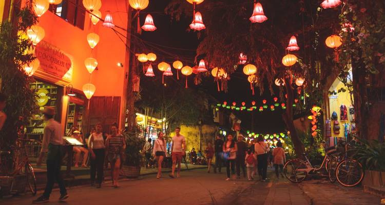 Drukke met lantaarns verlichte straat 's nachts met voetgangers in de oude stad van Hoi An.