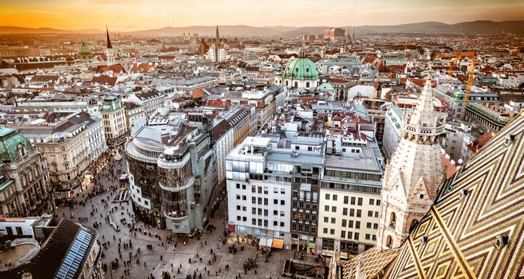 Vista aérea panorámica del centro histórico de Viena con la Catedral de San Esteban y el brillo del atardecer.