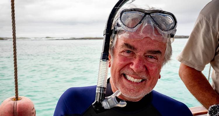 Glücklicher Schnorchler mit Maske und Neoprenanzug auf einem Boot in Galapagos.