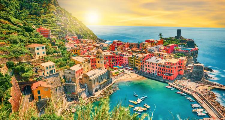 Vue spectaculaire à vol d'oiseau du village coloré de Vernazzo et de son port illuminés au coucher du soleil.