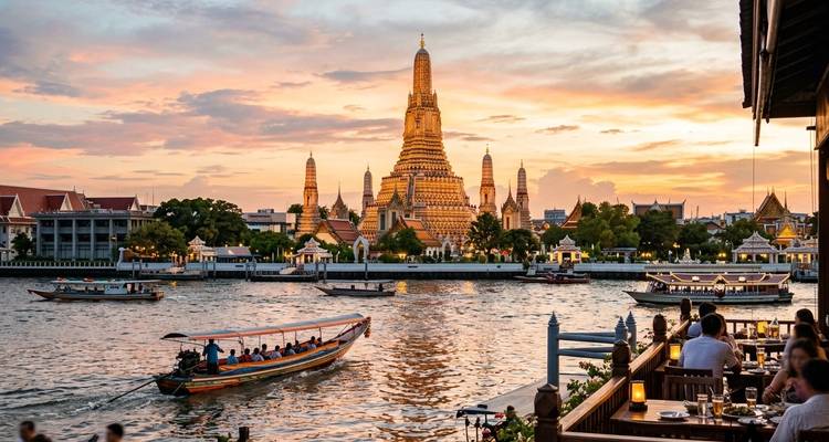 Le Wat Arun doré s'élève au-dessus du fleuve Chao Phraya tandis que les bateaux à longue queue naviguent au coucher du soleil.