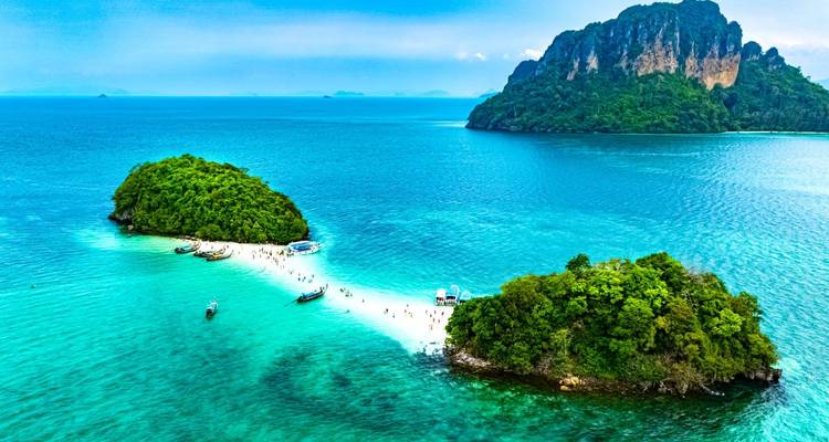 Vue aérienne de deux îlots luxuriants reliés par un banc de sable blanc entouré d'une mer turquoise brillante