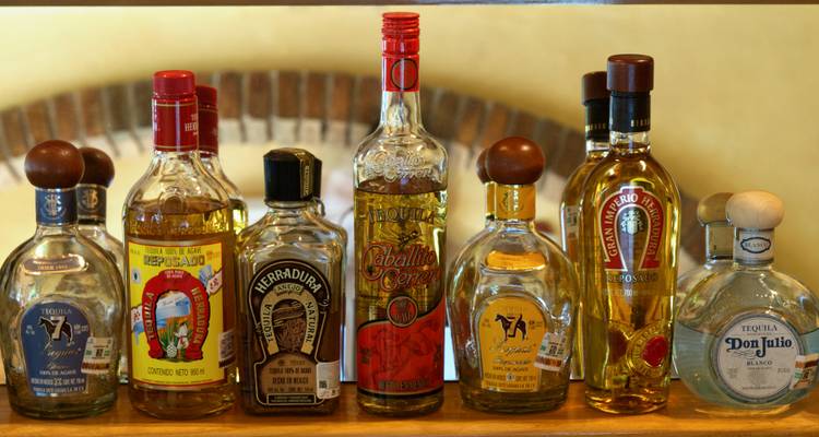 Botellas variadas de tequila premium alineadas en un estante