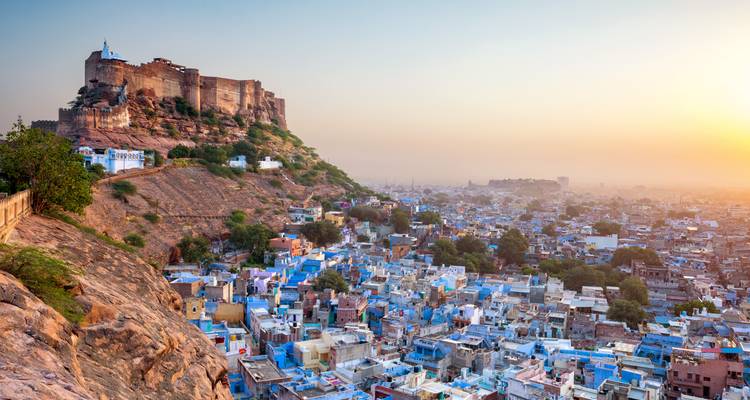 Panoramablick auf die blaugetünchten Häuser von Jodhpur unterhalb des Mehrangarh-Forts bei Sonnenaufgang.