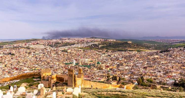 Vue panoramique sur l'ancienne ville de Fès avec des collines brumeuses au-delà