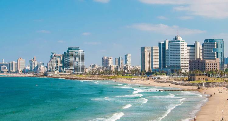 El moderno horizonte de Tel Aviv se eleva detrás de una hermosa playa mediterránea con olas turquesas y arena suave.