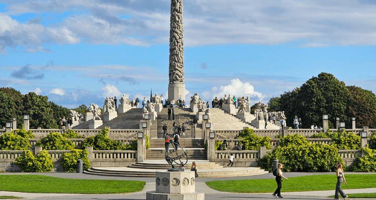 Monoliet en omringende beeldhouwwerken in Oslo's Vigeland Park onder blauwe hemel.