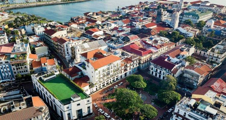 Fotografía aérea del distrito histórico Casco Viejo de la Ciudad de Panamá con techos coloridos junto a la orilla del agua.