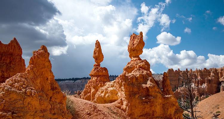 Einzigartige, ausgewogene Hoodoo-Formationen erheben sich vor einem Hintergrund aus blauem Himmel und Wolken.