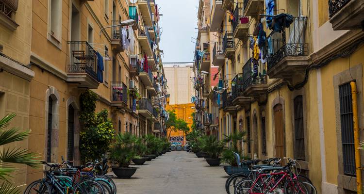 Ruelle résidentielle de Barcelone bordée de bicyclettes et de balcons avec du linge coloré