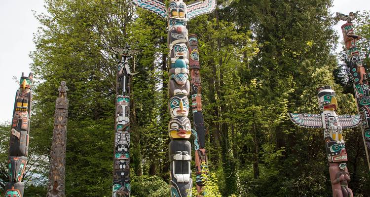De grands totems colorés se dressant dans une clairière de forêt verdoyante et luxuriante.