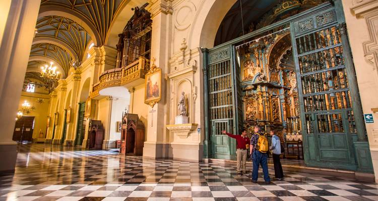 Grand intérieur de la Cathédrale de Lima avec un retable orné tandis que les visiteurs admirent l'architecture coloniale complexe.