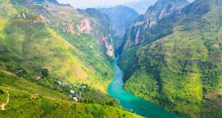 Cañón espectacular con acantilados verdes escarpados y un río turquesa serpenteando muy abajo.