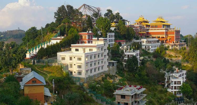 Los coloridos edificios del monasterio se posan en una colina verde sobre los pueblos circundantes en Namobuddha.
