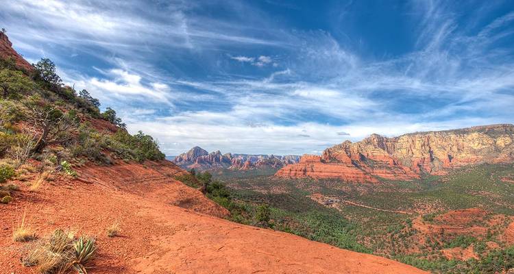 Wide vista of Sedona’s red rock formations beneath a dramatic sky.