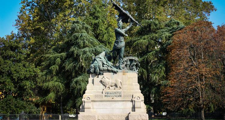 Monument de la Pierre Risorgimento avec des soldats en bronze et un lion situés au milieu de la verdure luxuriante du parc.