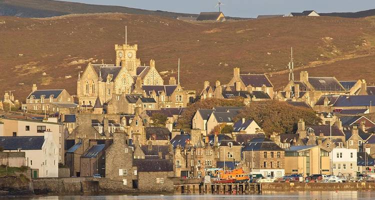 Les bâtiments historiques en pierre de Lerwick dominent le port sous la lumière de fin d'après-midi.