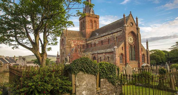 La cathédrale St Magnus s'élève au-dessus de l'ancien cimetière de Kirkwall entouré de verdure luxuriante.