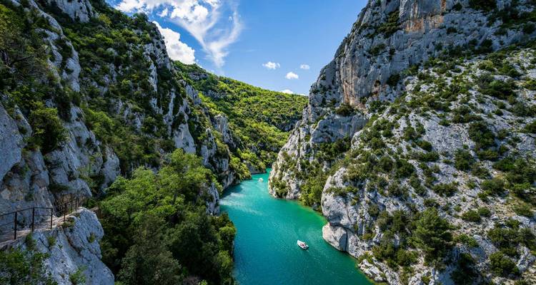 Les Gorges du Verdon Vert Émeraude serpentent entre des falaises de calcaire imposantes, un bateau solitaire flottant en dessous.