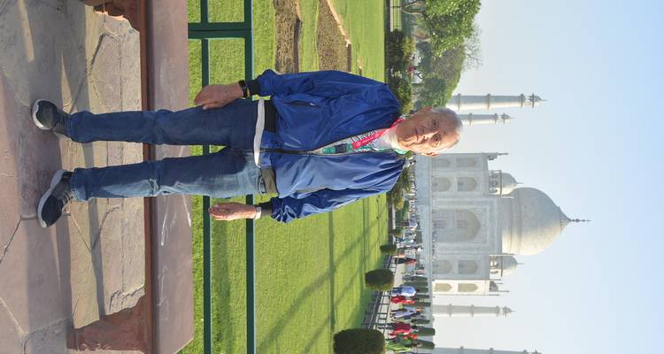 Oudere man die poseert voor de Taj Mahal in het ochtendlicht op het hoofdplein.