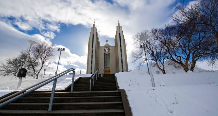 L'église en béton moderne d'Akureyri se dresse majestueusement encadrée contre un ciel d'hiver spectaculaire.